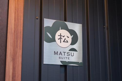 Un cartel en la puerta de la suite Aiting. en 由布の宿 YUFU-Inn 藤 松 プライベートな露天風呂付き-由布院駅徒歩2分, en Yufu