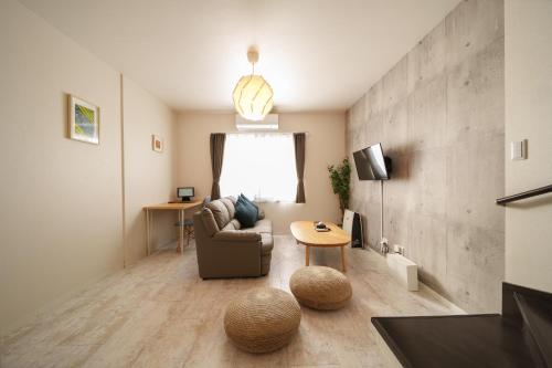 una sala de estar con un sofá y una mesa en 由布の宿 YUFU-Inn 藤 松 プライベートな露天風呂付き-由布院駅徒歩2分, en Yufu