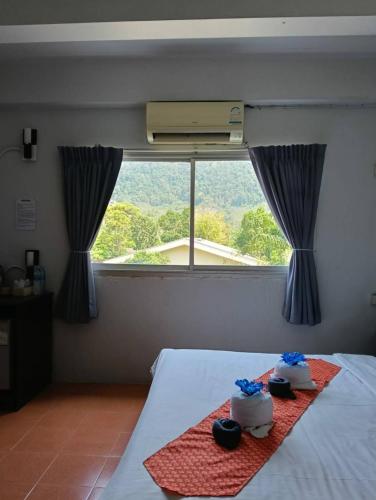 a bedroom with two cakes on a bed with a window at The Sunshine hostel and hotel in Ko Lanta