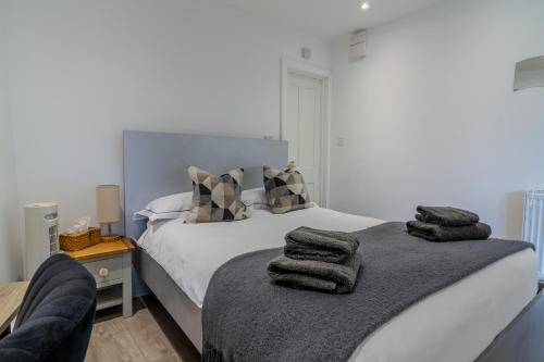 a bedroom with a bed with towels on it at Modern Studio Apartment with Free Wifi in Bromley