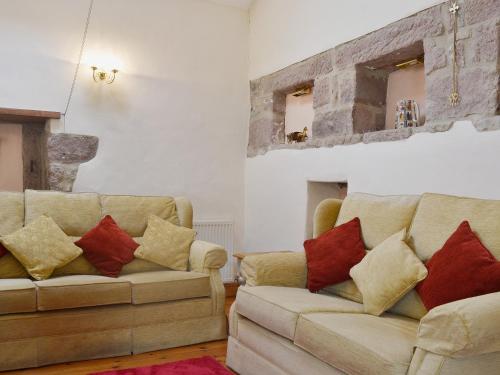 a living room with two couches with pillows at Barn Owl Cottage in Cromford