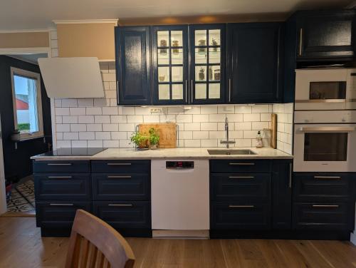 a kitchen with black cabinets and white appliances at Home in Vingåker in Vingåker