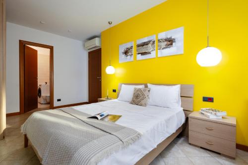 ein Schlafzimmer mit einem großen Bett mit einer gelben Wand in der Unterkunft Yerevan Elite Stay - Republic Square in Yerevan