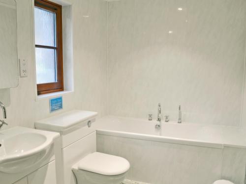 a white bathroom with a toilet and a sink at The Wheelhouse in Linlithgow
