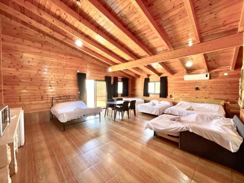 Cette grande chambre comprend plusieurs lits et une table. dans l'établissement וילות היוקרה עידן הנוף ואחוזת אסתובן, à Ya‘ara