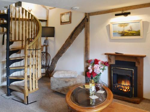 a living room with a staircase and a fireplace at Robins Nest - 29409 in Elmsted