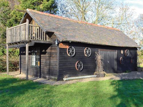 a wooden cabin with a balcony and a deck at Robins Nest - 29409 in Elmsted