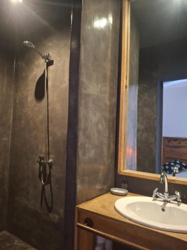 a bathroom with a sink and a shower and a mirror at Siki Hotel in Saint-Louis