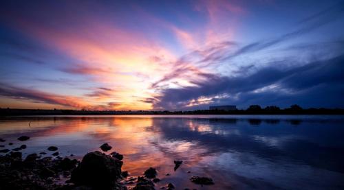 a sunset over a body of water with the sky at La Fenice in Mola di Bari