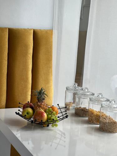 een bord fruit op een tafel met potten voedsel bij Southern Cross Guesthouse in Somerset West