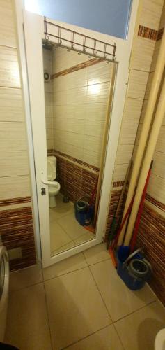 Un baño con inodoro y puerta corrediza de cristal. en shared rooms, en Pristina