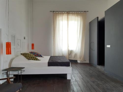 a bedroom with a large white bed and a window at Siki Hotel in Saint-Louis
