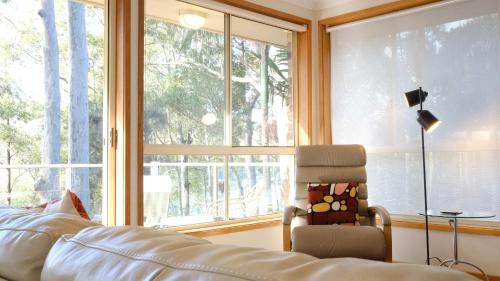 ein Schlafzimmer mit einem Stuhl und einem großen Fenster in der Unterkunft Hardys Bay View From Every Window in Hardys Bay