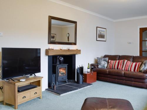 a living room with a couch and a fireplace at Tigh Raineach in Strathyre