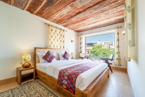 a bedroom with a bed and a large window at The Munshi Mansion in Jodhpur