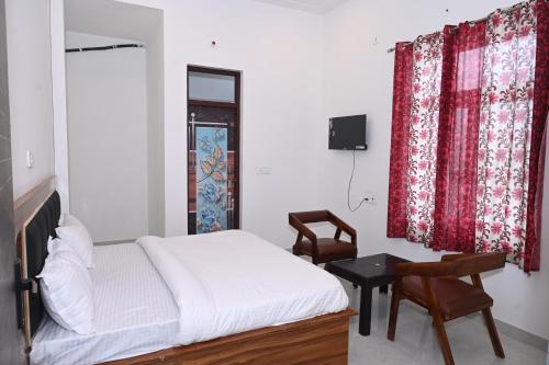 a bedroom with a bed and a desk and chairs at Hotel Sanjay palace in Mahwah
