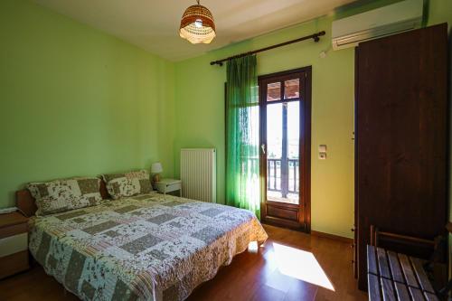 een groene slaapkamer met een bed en een raam bij Asano's House in Agios Nikolaos