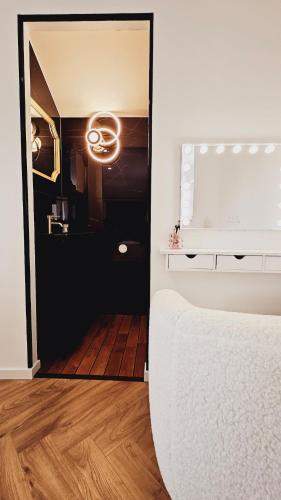 a bedroom with a white bed and a mirror at La signature d'Alsace in Bennwihr