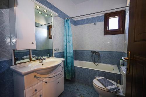 een badkamer met een wastafel, een toilet en een bad bij Asano's House in Agios Nikolaos
