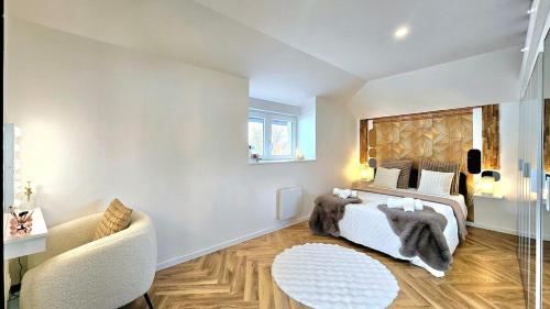 een slaapkamer met een groot bed en een stoel bij La signature d'Alsace in Bennwihr