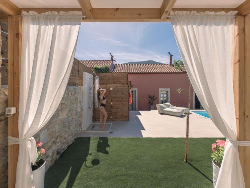 una mujer está parada en la puerta de una casa en Arhontiko Arhanes Suites, en Archanes