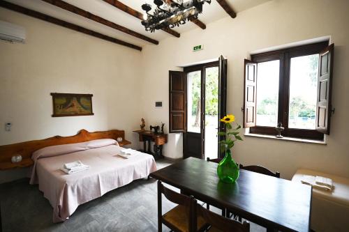 Un dormitorio con una cama y una mesa con un jarrón encima. en Agriturismo Gli Aranci dell'Etna, en Mascali