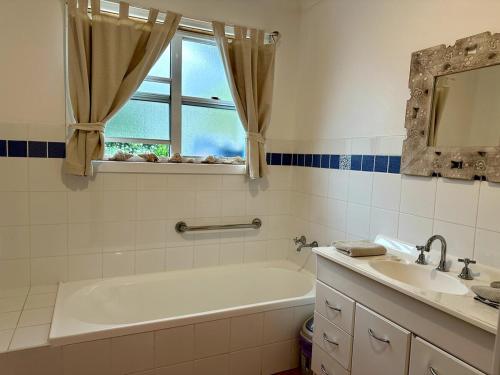 ローブにあるDunes Blue at Robeの浴槽と洗面台と窓のあるバスルーム