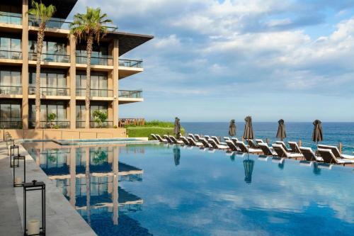 a swimming pool with chairs and a building at Casa Maat at JW Marriott Los Cabos Beach Resort & Spa in San José del Cabo