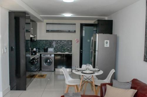 Una cocina y un comedor con mesa y sillas. en Twilight Self Catering, en Windhoek