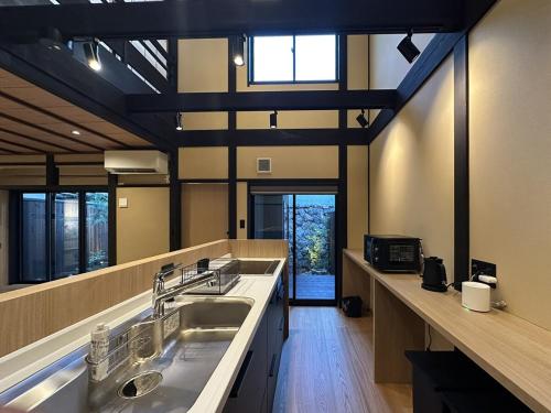 a large kitchen with two sinks and a large window at Authentic Kyoto Machiya Sleeps 7 Near Station in Fushimi