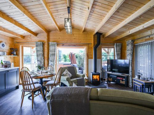 a living room with a couch and a tv at Stable Lodge At Greenacre in Bromyard