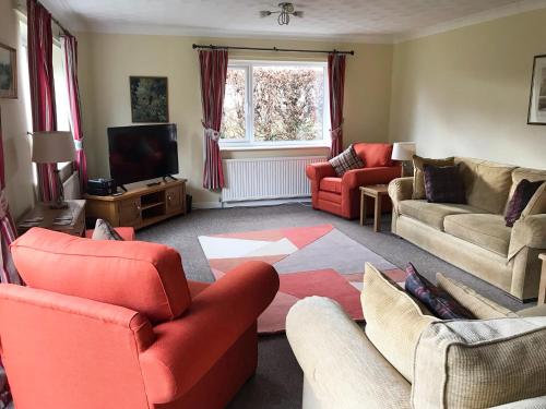 a living room with red furniture and a television at Kestral in Welney