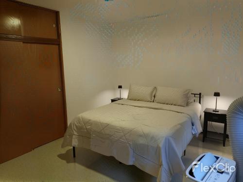 a bedroom with a bed and a wall with a painting at Apartamento Amplio Cerca de Todo con Seguridad y con Todas las Comodidades de un Hospedaje Renovado y Totalmente Equipado, ademas Tene Wi-Fi de Alta Velocidad in Caracas