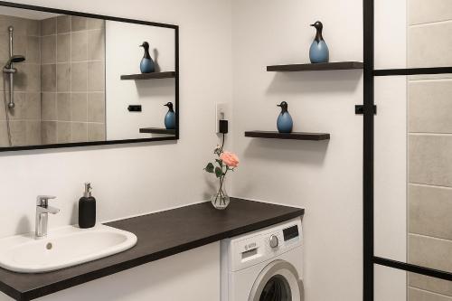 a bathroom with a sink and a washing machine at Strandhuset i Øster Hurup in Øster Hurup