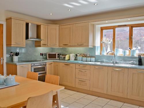 a kitchen with wooden cabinets and a wooden table at Fenn House in Alvechurch