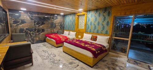 une chambre avec deux lits et une chaise et une fenêtre dans l'établissement Ashok Villa, à Mount Âbû