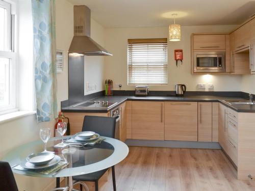 a kitchen with a table and a dining room at The Parade Apartment in Reighton
