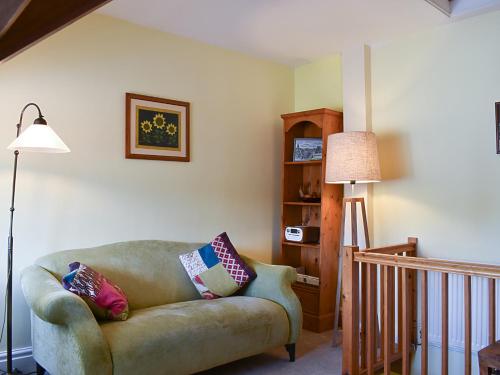 a living room with a couch and a lamp at Upper Sycamore Cottage in Ambleside