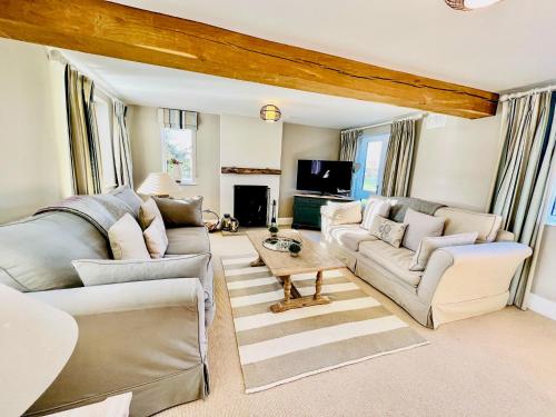 a living room with two couches and a tv at Gilbertson Cottage in Wheldrake