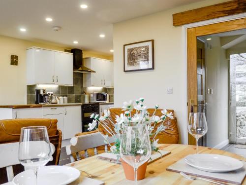 uma cozinha e sala de jantar com uma mesa com flores em Dutch Barn One - Uk12872 em Brynkir