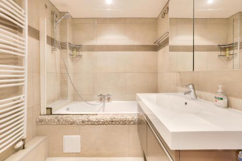 ein Badezimmer mit Waschbecken und Badewanne in der Unterkunft Appartement spacieux au cœur de Strasbourg in Straßburg
