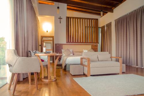 a bedroom with a bed and a table and a couch at Six Elements Beach Villa in Tangalle