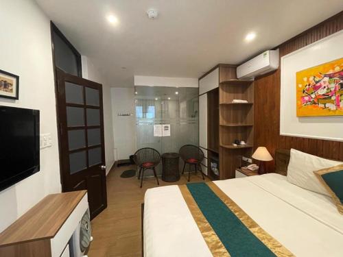 a bedroom with a bed and a tv and a room at Hoan Kiem Old Quarter Hotel Alley 22 Hang Voi in Hanoi