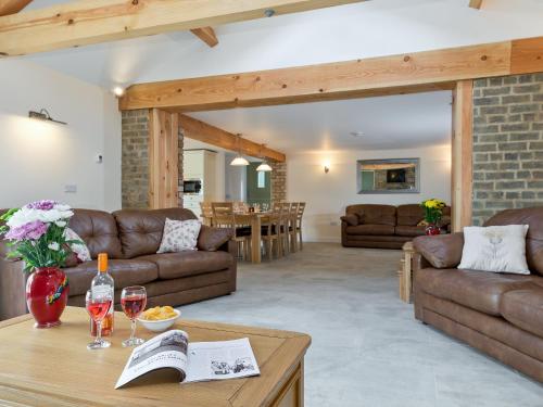 ein Wohnzimmer mit Sofa und Tisch in der Unterkunft Eastlands Barn in East Barkwith
