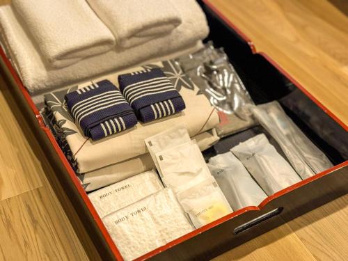 an open suitcase filled with towels and other items at Ryokan YUFUMOMIJI in Yufuin