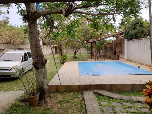a car parked in a yard with a swimming pool at Casa do sossego - conforto, praia, piscina in Maricá