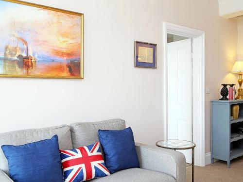 a living room with a couch and a painting on the wall at Skyfall in Canterbury