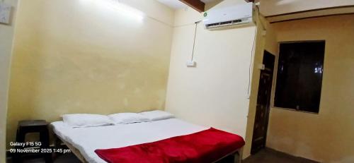 a small room with a bed with a red blanket at Divya ganga hotel in Varanasi