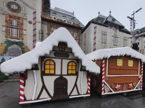 two gingerbread houses with snow on top of them at Apartament 2 dormitoare ultracentral modern in Craiova