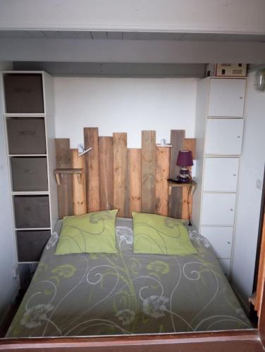 a bedroom with a bed with a wooden headboard at Le Charme des Barcarelles in Le Barcarès